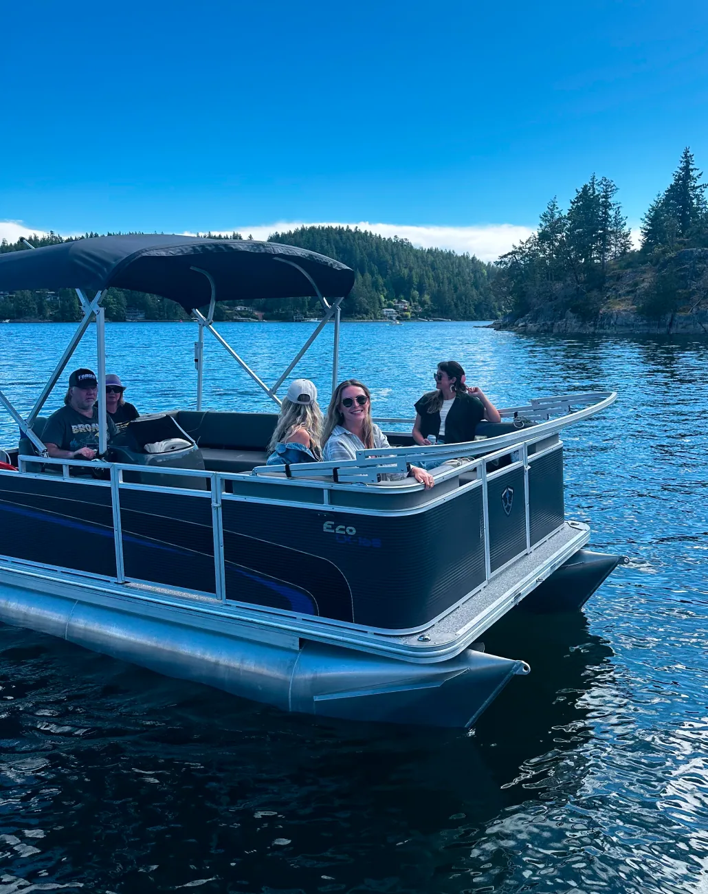 Pontoon boat drifting across the glassy waters of Pender Harbour