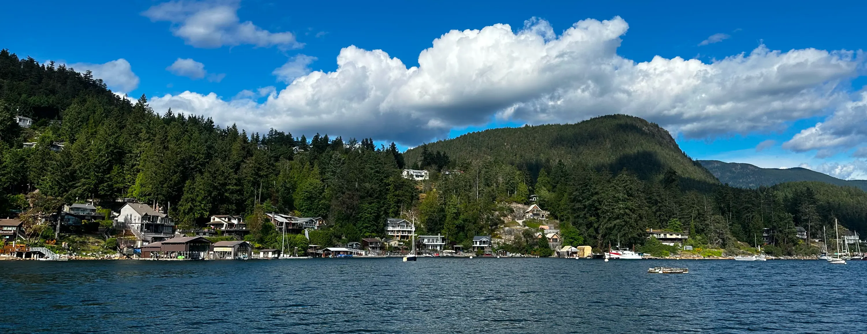 Pontoon boat cruising through the calm waters of Pender Harbour